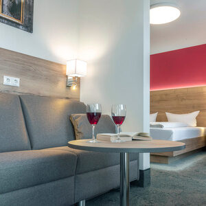 Auf einem Kaffeetisch stehen zwei Weingl&auml;ser im Doppelzimmer Komfort